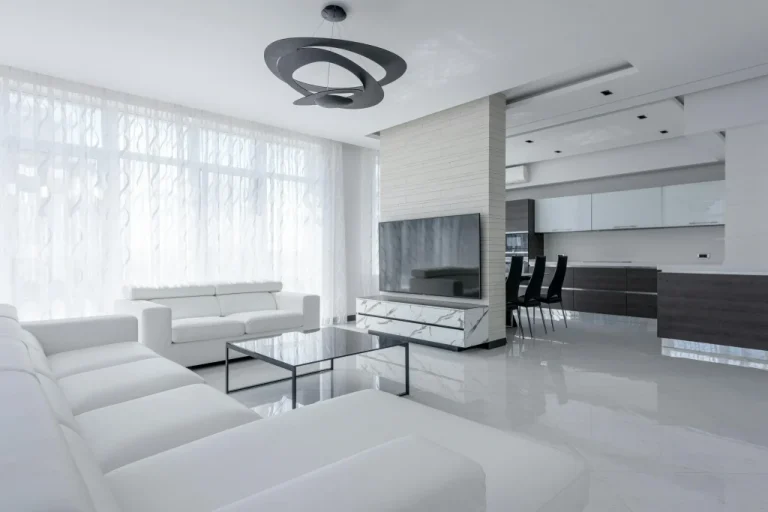 Modern luxury living room and kitchen interior in Bangkok with white tones, contemporary furniture and natural light